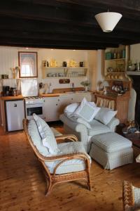 a living room with a couch and chairs and a kitchen at Charoul'Hôtes Gîtes et roulotte insolite in Saint-André-sur-Sèvre