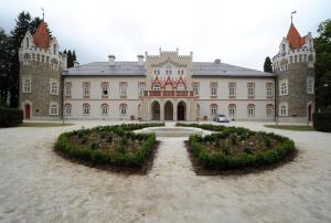 a large castle with a garden in front of it at Chateau Herálec Boutique Hotel & Spa by L'Occitane in Herálec