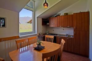 une cuisine avec une table en bois et une grande fenêtre dans l'établissement Apartments Jojo, à Bovec