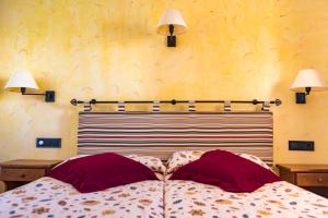 a bedroom with a bed with two pillows and two lamps at Apartamentos Mar y Sal in La Savina