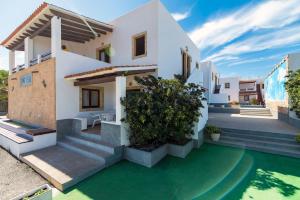 a villa with a pool in front of a house at Apartamentos Mar y Sal in La Savina