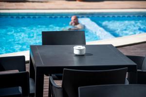 a coffee cup sitting on a table in front of a swimming pool at Apartamentos Mar y Sal in La Savina