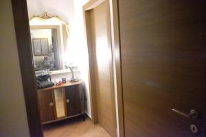 a bathroom with a wooden door and a mirror at Dimora del Casale in Brindisi
