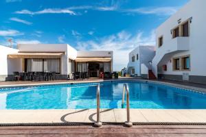 a swimming pool in front of a building at Apartamentos Mar y Sal in La Savina