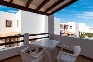 a white table and chairs on a balcony with a view at Apartamentos Mar y Sal in La Savina