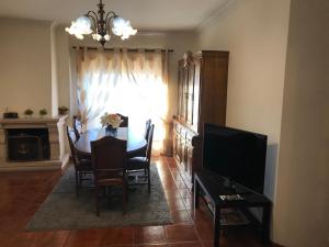 una sala da pranzo con tavolo e TV di Casa do Rodrigo a Mondim de Basto