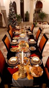 een lange tafel met eten en een kerstboom bij Riad Nirvana in Marrakesh