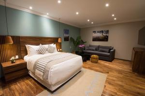 Casa Santiago Hotel Boutique في كيريتارو: غرفة نوم بسرير كبير وأريكة