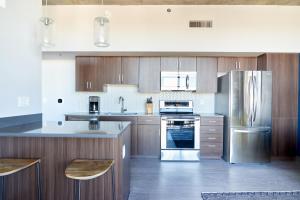 a kitchen with wooden cabinets and stainless steel appliances at Sonder at McKinley in Phoenix
