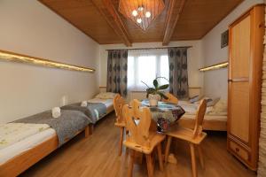 ビャウカにあるMałgosia Regionalna - 10 minut na piechotę do stoku narciarskiego i term Bania - atrakcyjny pakiet wielkanocnyのベッド3台、テーブル、椅子が備わる客室です。