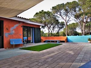 un patio con banco, mesa y césped en Casa mutreku 1m from the beach,2 kitchens, 2 showers, en Cala Liberotto