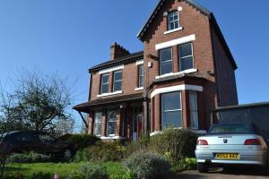 a brick house with a car parked in front of it at Ms McCreadys Guest House in Doncaster