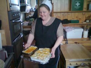una mujer en una cocina sosteniendo una bandeja de pasteles en Ms McCreadys Guest House, en Doncaster