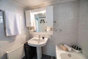 ein weißes Badezimmer mit einem Waschbecken und einem Spiegel in der Unterkunft LefkasLoft in Lefkada Town