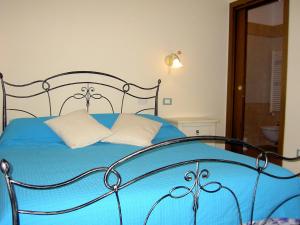 a blue bed with two white pillows on it at Agriturismo Monteortone in Abano Terme