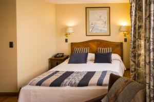 a bedroom with a large bed with blue pillows at Alessandria Apart - Coronel Pereira in Santiago