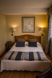 a bedroom with a large bed with blue pillows at Alessandria Apart - Coronel Pereira in Santiago