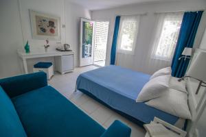 una camera con un letto blu e un divano di Blue & White Hotel a Çıralı