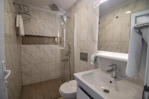a bathroom with a sink and a toilet at Blue & White Hotel in Cıralı +70 photos