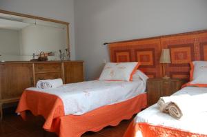 a bedroom with two beds and a mirror at Casa Luna Lunera in Ayllón