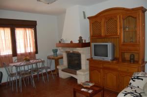 sala de estar con TV y chimenea en Casa Luna Lunera en Ayllón