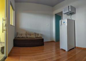 a living room with a couch and a refrigerator at KITNET'S DA DENI in Alto Paraíso de Goiás