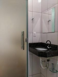 y baño con lavabo y espejo. en KITNET'S DA DENI, en Alto Paraíso de Goiás