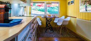 una cucina con tavolo e due sedie bianche di Bellevue Aschberg a Klingenthal