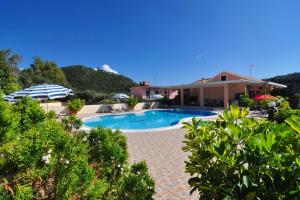 a swimming pool in front of a house at Marilena Studios And Apartments in Paleokastritsa