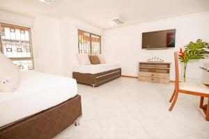 1 dormitorio con 2 camas y TV en San Fernando Suite 101 - Livin Colombia, en Cali