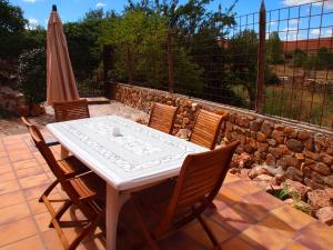 einen Tisch, Stühle und einen Regenschirm auf einer Terrasse in der Unterkunft Casa Luna Lunera in Ayllón