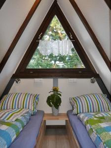 SchellbronnにあるFerienhaus im Nordschwarzwald - Nurdachhaus in Waldrandlage Haus Florineのベッド2台と窓が備わる屋根裏部屋です。