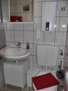Baño blanco con lavabo y aseo en Ferienhaus im Nordschwarzwald - Nurdachhaus in Waldrandlage Haus Florine, en Schellbronn