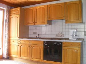 a kitchen with wooden cabinets and a stove top oven at Haus Waldblick in Auffach