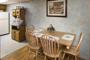 a kitchen with a wooden table with chairs and a refrigerator at River Place Condos #602 2BD in Pigeon Forge