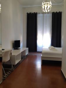 a room with a bed and a desk and a window at Cagliari d'Amare Via Roma in Cagliari