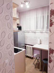 a kitchen with white appliances and a table with chairs at Narva mnt 23 in Jõhvi