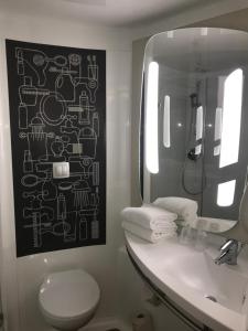 カリュイール・エ・キュイールにあるibis Lyon Caluire Cité Internationaleのバスルーム(鏡、トイレ、洗面台付)