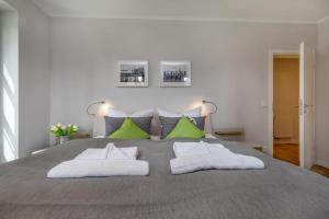 a bedroom with a large bed with green pillows at Ostseereise in Zingst