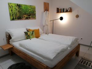 Bett mit weißer Bettwäsche in einem Zimmer in der Unterkunft Ferienwohnung Grete in Trier