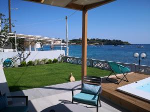 a patio with chairs and a swimming pool and the water at LENICO Seafront Villa in Agia Pelagia