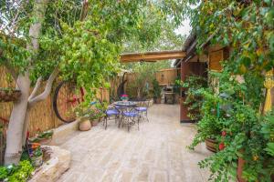 a patio with a table and chairs and trees at farmer’s suite room in Bat Shelomo