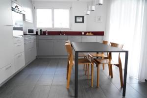 a kitchen with a black table and chairs at Wohnen wie Zuhause in Sagogn