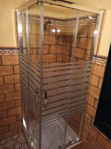 ducha con puertas de cristal y pared de ladrillo en El Peñón, en Zahara de la Sierra