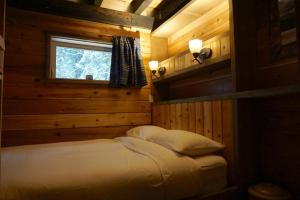a bedroom with two beds in a log cabin at Logden Lodge in Nelson