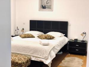 a bedroom with a large bed with a black headboard at Fatima Studio in Fátima