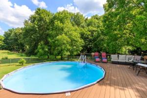 a large blue swimming pool on a deck with trees at Brenda Lee History 4BR Retreat Pool Hot Tub in Nashville