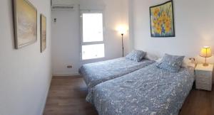 sypialnia z dwoma łóżkami i oknem w obiekcie Beachfront 82 w mieście Torrox Costa