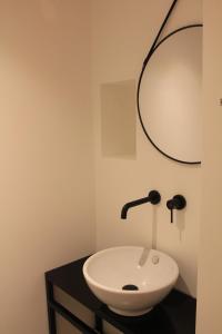 ein Badezimmer mit einem weißen Waschbecken und einem Spiegel in der Unterkunft B&B COCO in Calvisano