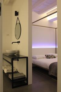 ein Bad mit einem Spiegel, einem Waschbecken und einem Bett in der Unterkunft B&B COCO in Calvisano